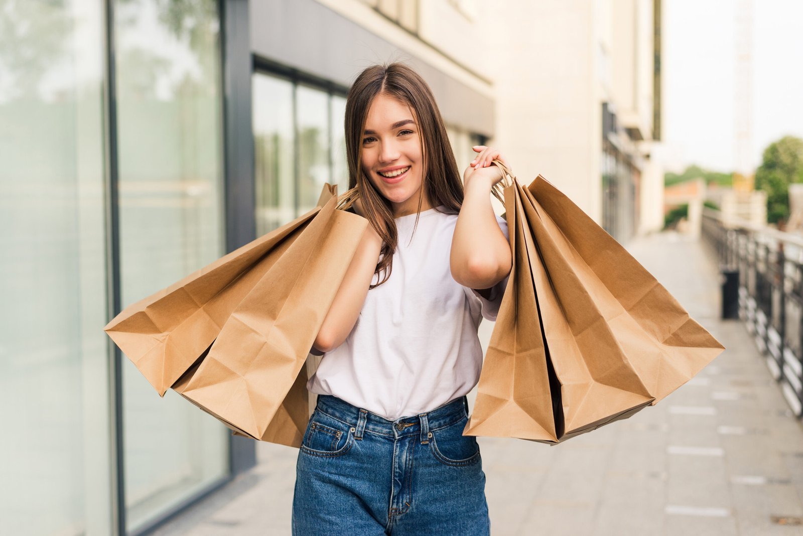 Beautiful woman holding shopping bags and smiling - outdoors